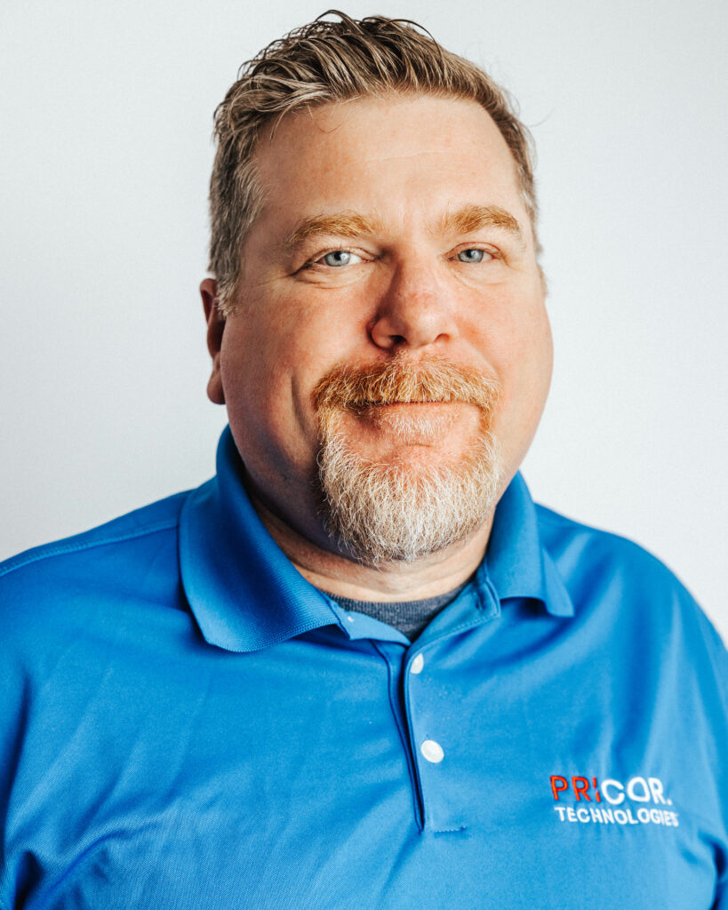 Headshot of PRICOR Technologies co-founder Jason Pritchard smiling in a blue golf shirt.
